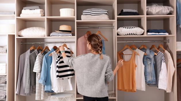 Γυναίκα τακτοποιεί ρούχα ντουλάπα