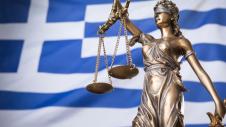 Θέμιδα μπροστά σε ελληνική σημαία